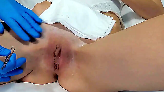 Brunette gets waxed by sexy beautician in blue latex gloves